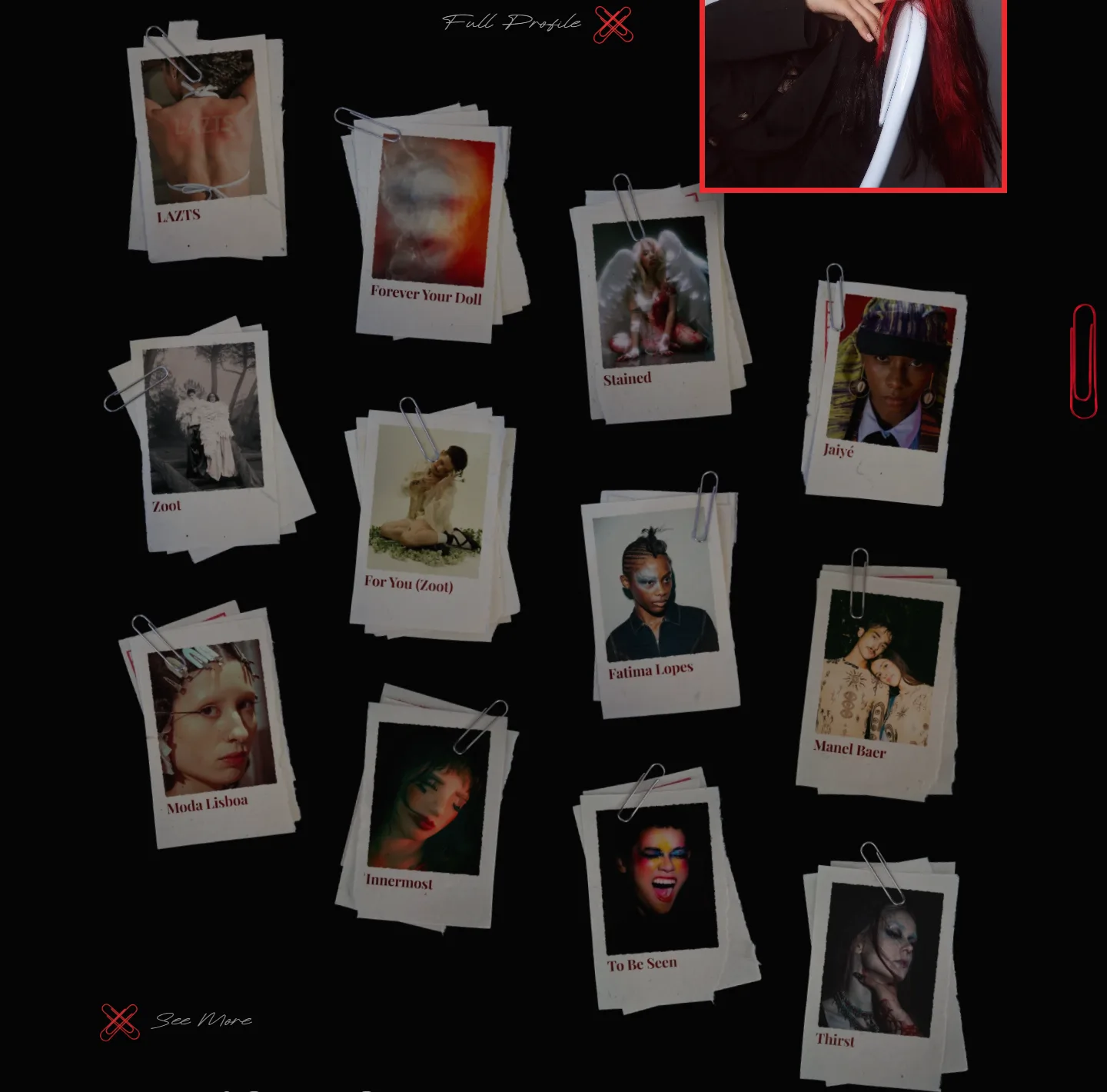 Twelve paper-print cards scattered across black at different tilts, each held by a silver paperclip and titled underneath, from LAZTS and Forever Your Doll to Stained and Thirst, with “See More” beside a pair of crossed red clips.