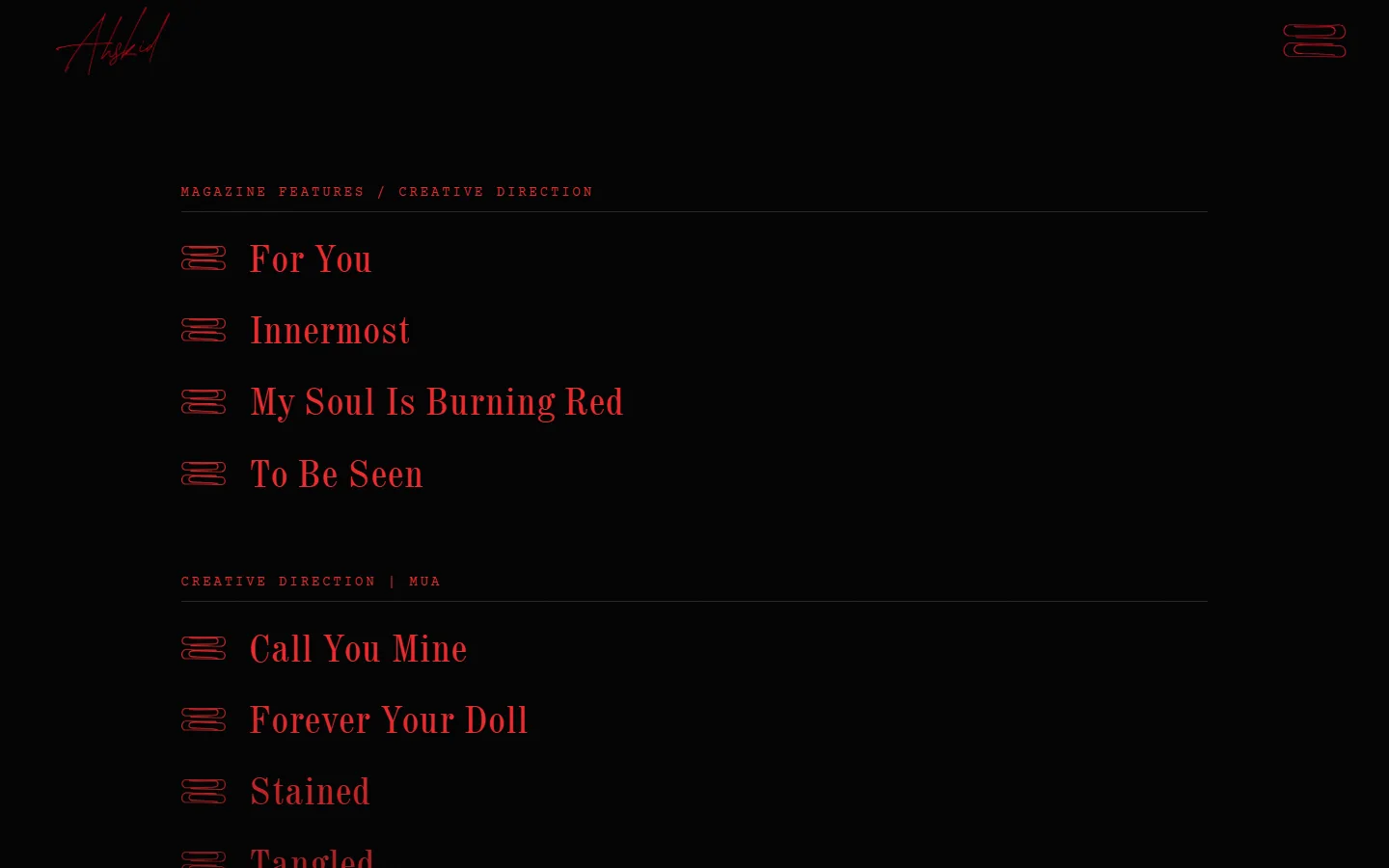 The projects page: a mono red label, “Magazine Features / Creative Direction”, above shoot titles in large red serif type, each beside a double paperclip.