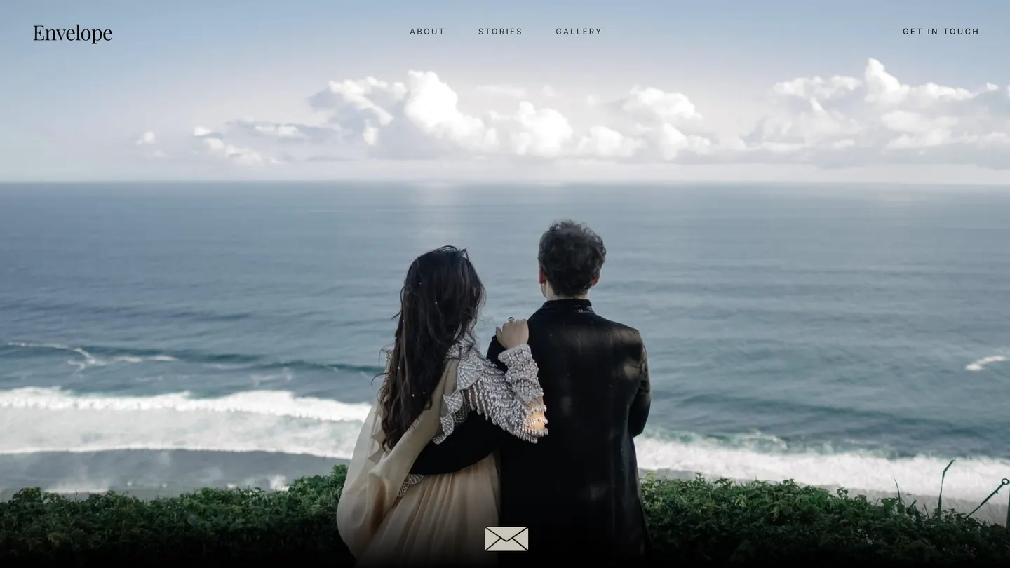 The Envelope home page: a full-bleed photograph of a couple looking out over the ocean, with an envelope mark at the foot of the frame.