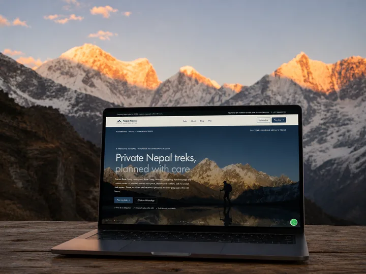 The Nepal Nexus home page on a laptop, standing on a wooden table in front of the Himalaya at sunrise.